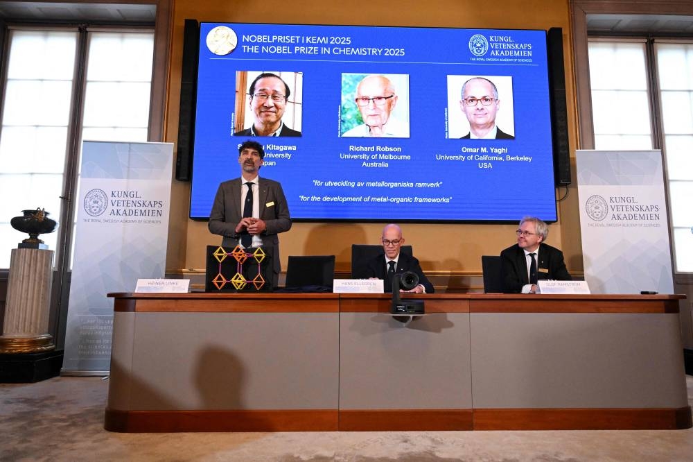 Heiner Linke (L), Chair of the Nobel Committee for Chemistry, explains a model as Hans Ellegren (C), Secretary General of The Royal Swedish Academy of Sciences, and Olof Ramstroem, Member of the Nobel Committe for Chemistry, listen during a press conference on the announcement of the winners of the 2025 Nobel Prize in Chemistry at the Royal Swedish Academy of Sciences in Stockholm, Sweden, on Wednesday. AFP