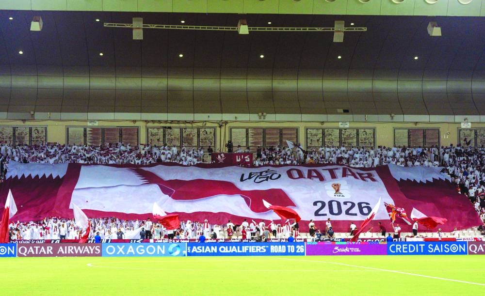 Qatar fans unfurl a tifo with a FIFA World Cup 2026 logo and “Let’s go Qatar” call.