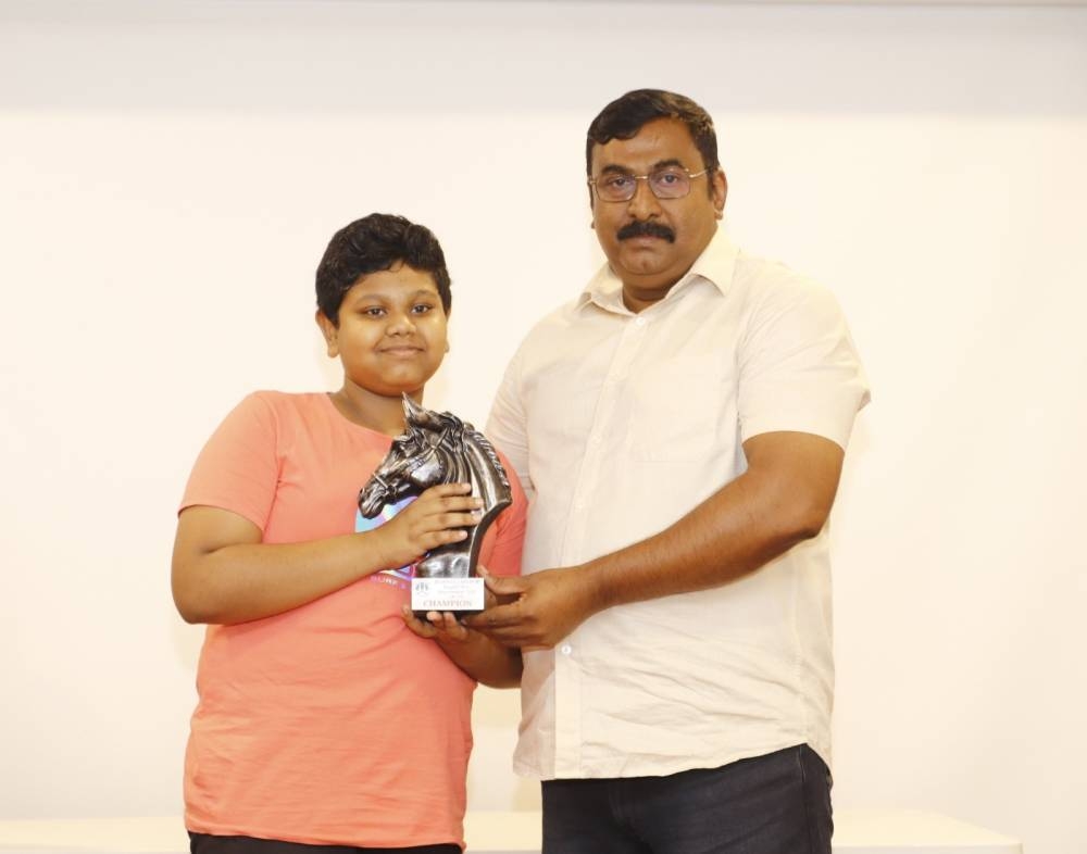 U-15 champion Kishore Arunagiri receives his prize from tournament director Jaise Joseph.