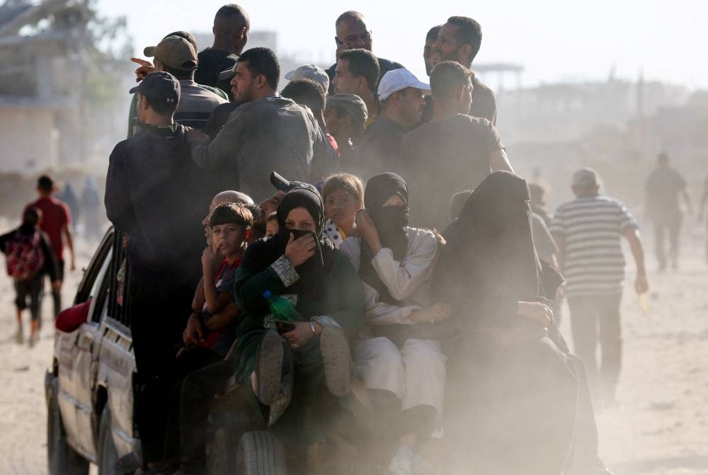 Palestinians return to their neighborhood, following Israeli forces' withdrawal from the area, amid a ceasefire between Israel and Hamas in Gaza, in Khan Younis, in the southern Gaza Strip October 11, 2025. REUTERS