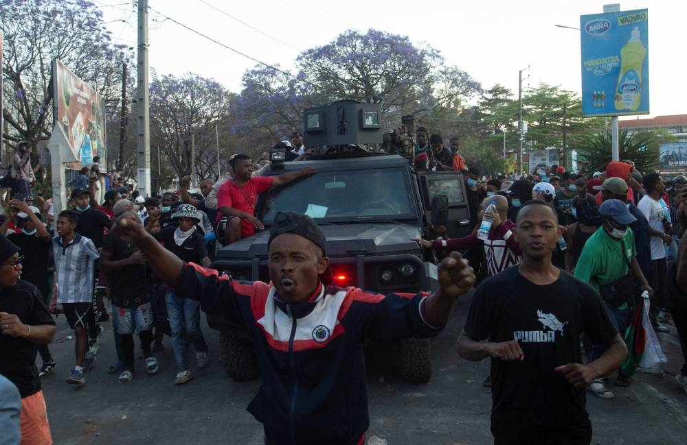 Protesters march alongside a Madagascar military vehicle during a nationwide youth-led protest over frequent power outages and water shortages, in Antananarivo, Madagascar, on Saturday. REUTERS