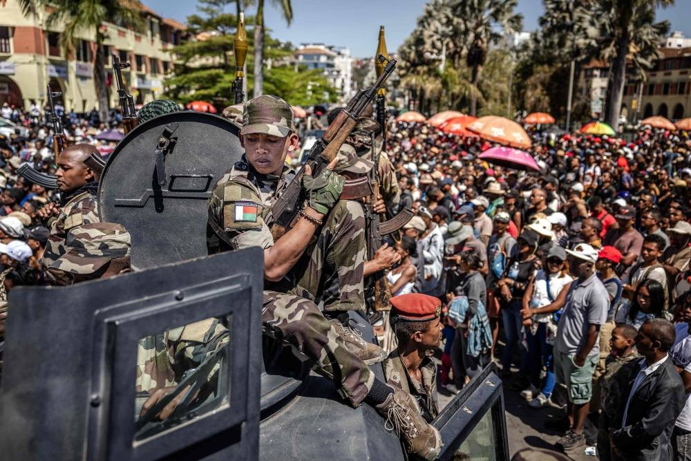 Members of Madagascar’s CAPSAT army unit patrol on an armoured vehicle as residents gather for a ceremony honouring protesters killed in anti-government demonstrations in Antananarivo, on October 12, 2025. A mutinied army unit declared, on Sunday. AFP