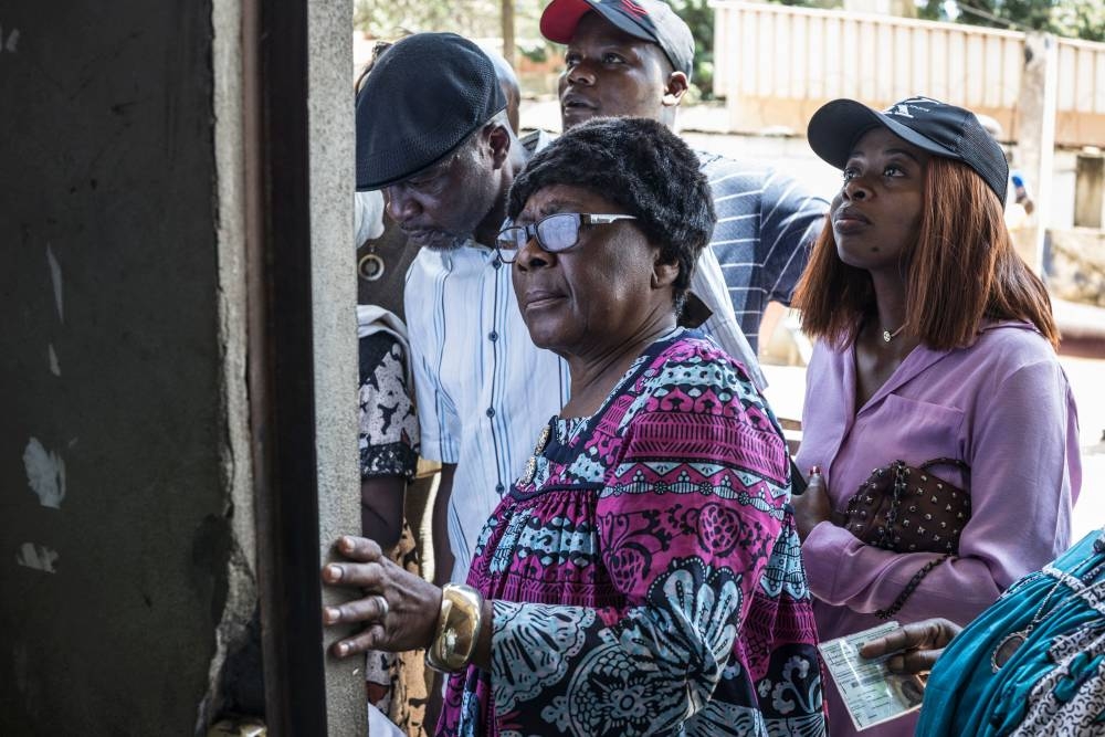 Voters check the voters' roll before queueing at a polling station in Yaounde, on Sunday during Cameroon's presidential election. AFP