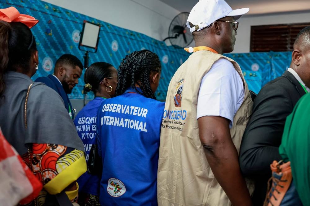 International election observers gather at a polling station in Yaounde on Sunday during Cameroon's presidential election. AFP