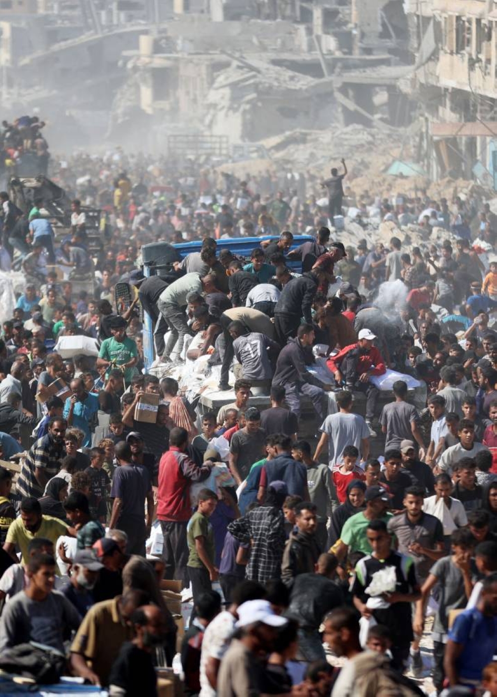 Palestinians rally around aid trucks in Khan Yunis in the southern Gaza Strip Sunday