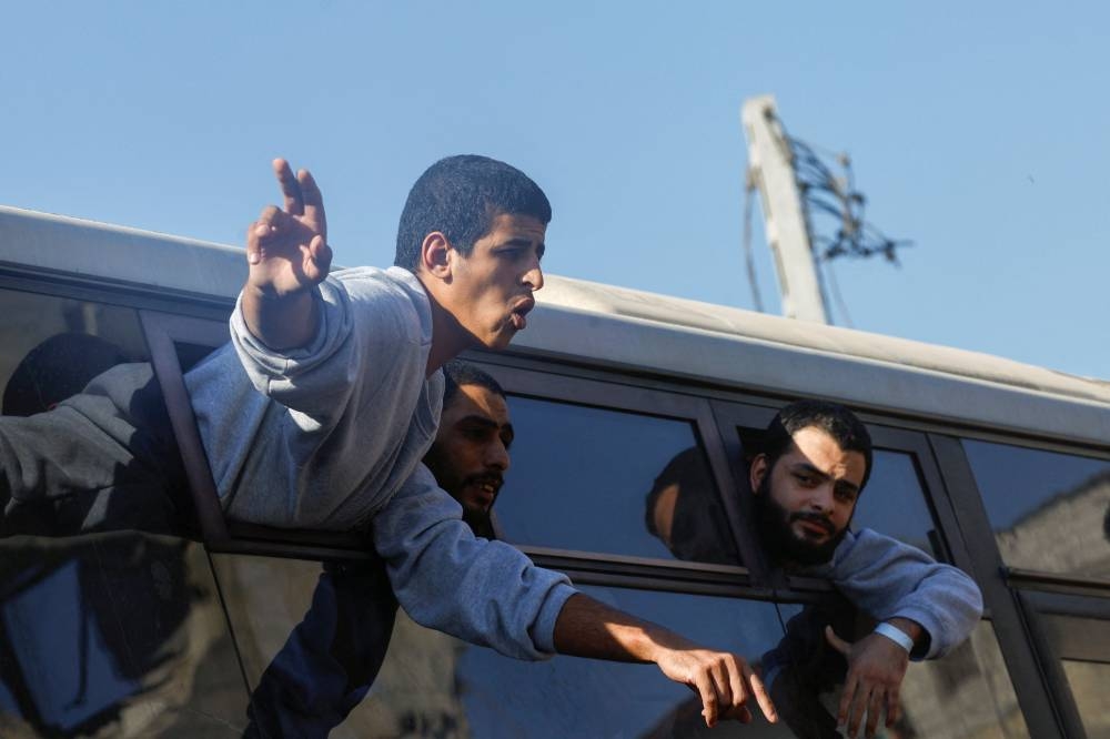 Freed Palestinian prisoners gesture from a bus after they were released by Israel as part of a hostages-prisoners swap and a ceasefire deal between Hamas and Israel, in Khan Younis in the southern Gaza Strip, October 13, 2025. REUTERS