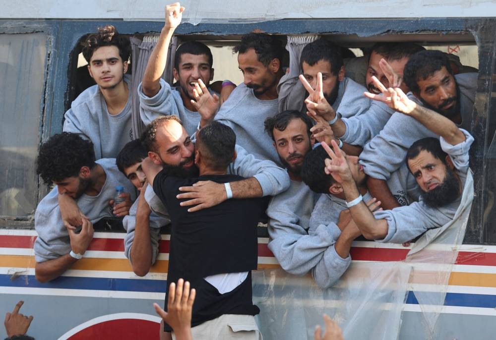 Freed Palestinian prisoners released by Israel as part of a hostages-prisoners swap and a ceasefire deal between Hamas and Israel, gesture,  in Khan Younis in the southern Gaza Strip, on Monday. REUTERS