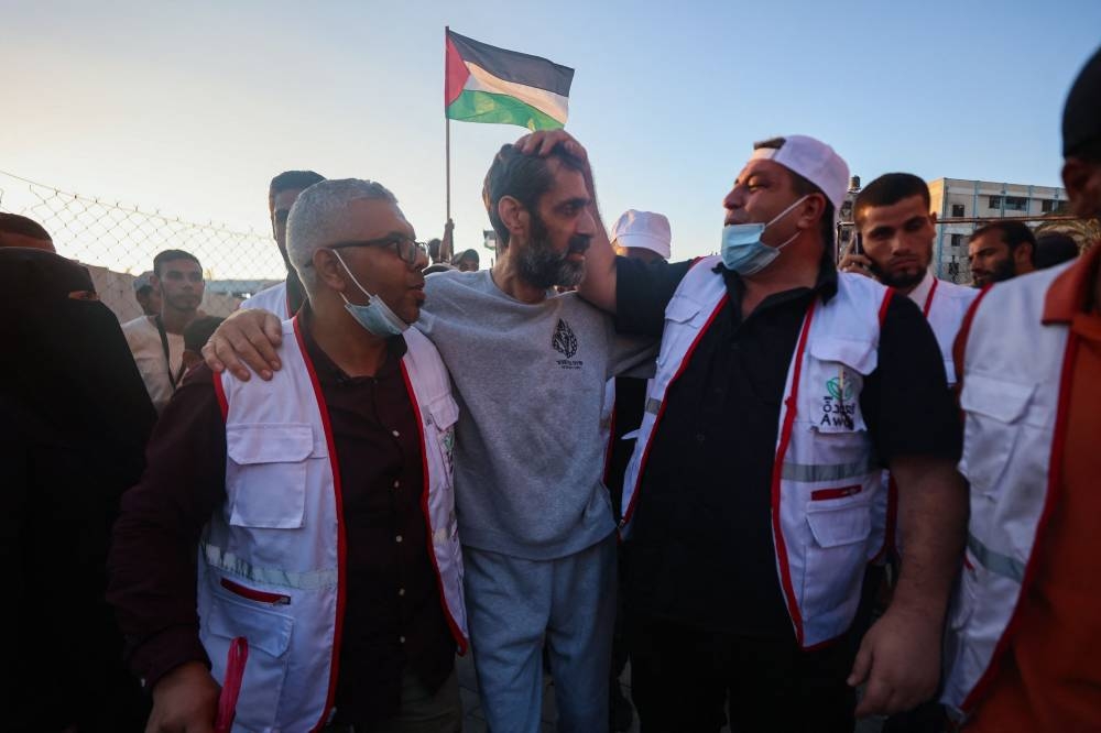 Palestinian hospital staff and well-wishers welcome the director of northern Gaza's Al-Awda Hospital Dr. Ahmad Mhanna, who was detained by Israeli forces from the hospital on December 18, 2023, following his release and arrival at the Nasser hospital in Khan Yunis in the southern Gaza Strip on Monday. AFP
