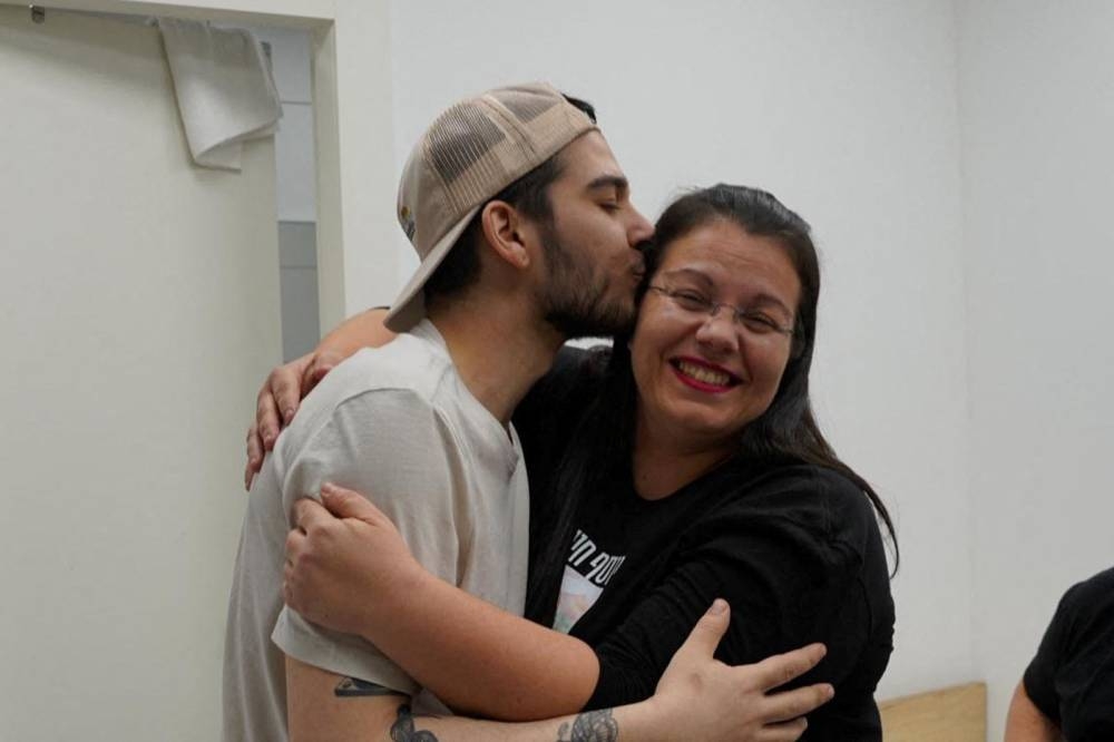Released Israeli hostage, Yosef-Chaim Ohana kisses his mother after being released, in Reim, Israel on Monday. Israel Defense Forces/Handout via REUTERS