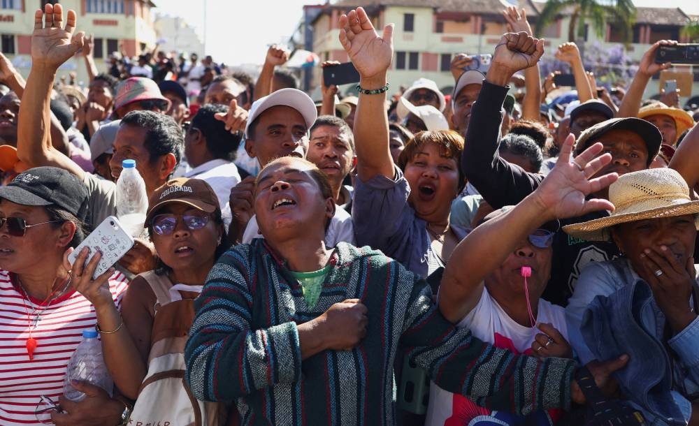 Locals react as members of the military arrive to join protesters gathered outside the town hall on Independence Avenue during a nationwide youth-led demonstration against frequent power outages and water shortages, in Antananarivo, Madagascar, on Tuesday. REUTERS