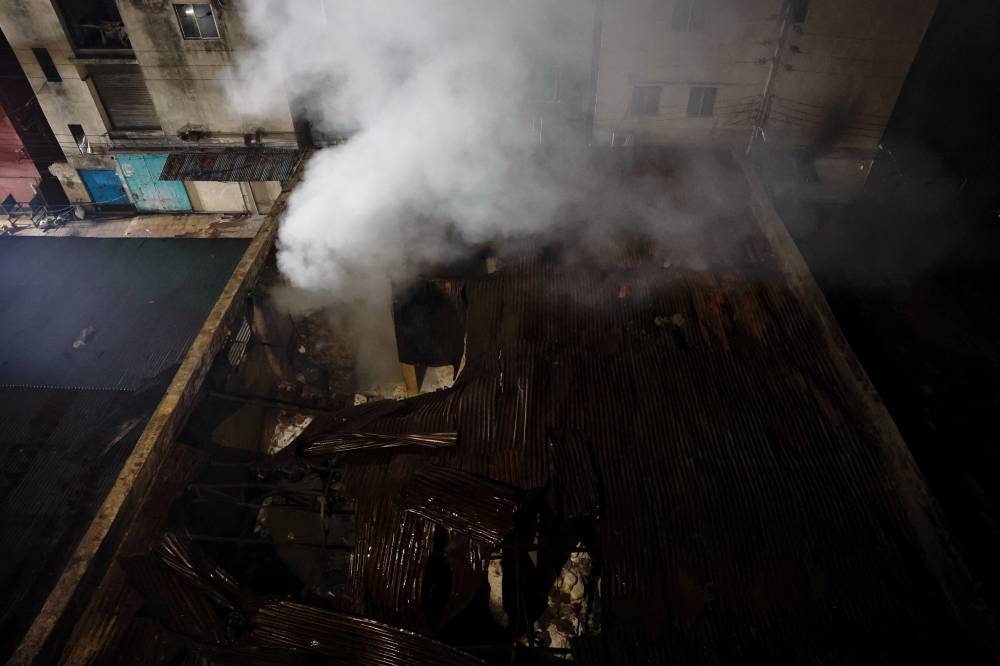 Smoke rises from a chemical warehouse opposite of a garments factory, after a fire broke out, in Dhaka, on Tuesday. REUTERS