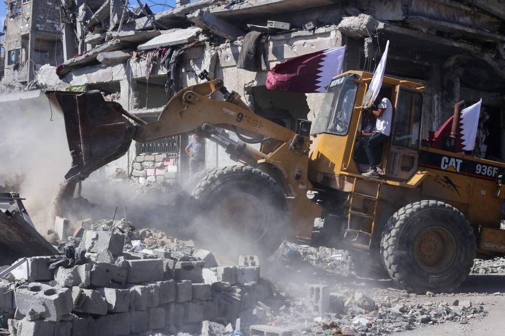 A bulldozer deployed by the Gaza Municipality clears building rubble from streets in Gaza City, Tuesday.