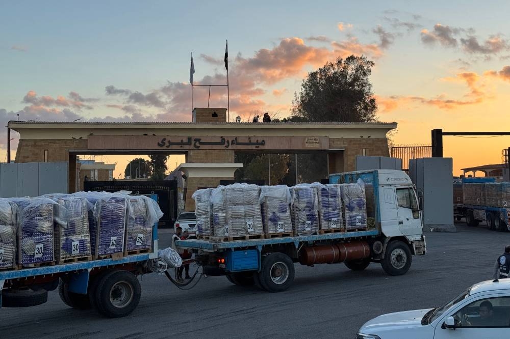 Trucks loaded with humanitarian aid on the Egyptian side of the Rafah crossing wait to cross into the Gaza Strip early on Wednesday. AFP