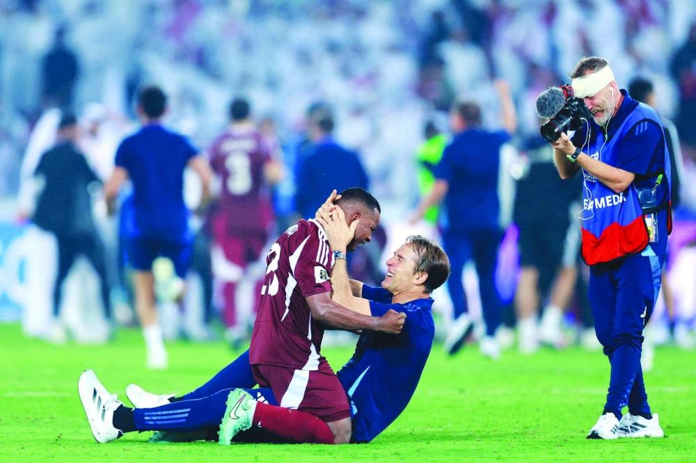 Qatar's defender #23 Assim Madibo celebrates with Qatar's Spanish coach Julian Lopetegui after the FIFA World Cup 2026 Asian qualifier football match between Qatar and the UAE at Jassim Bin Hamad Stadium in Doha on Tuesday. AFP