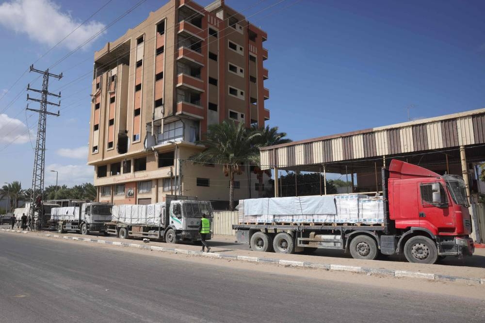 Trucks carrying aid provided by the World Food Programme (WFP) drive on a road in Deir el-Balah after entering through the Kerem Shalom crossing in the southern Gaza Strip, on Friday. AFP