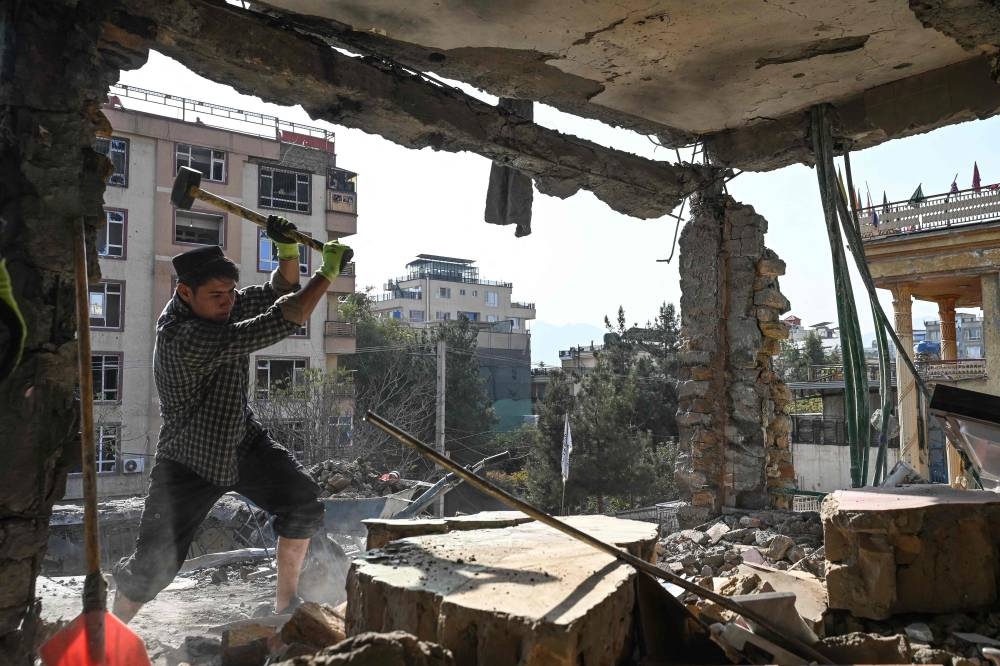 An Afghan man removes debris from a house, which was damaged after an air strike during cross-border clashes between Afghanistan and Pakistan, in Kabul on Thursday. AFP