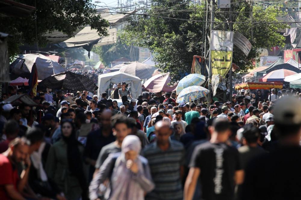 Palestinians gather at a market in Deir el-Balah in the central Gaza Strip, more than a week after a ceasefire agreement between Israel and Hamas took hold, on Saturday. AFP