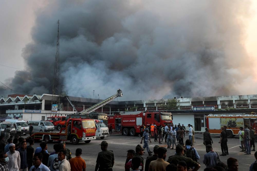 Onlookers gather as firefighters try to extinguish a fire that broke out in the cargo section of Hazrat Shahjalal International Airport in Dhaka on Saturday.  AFP
