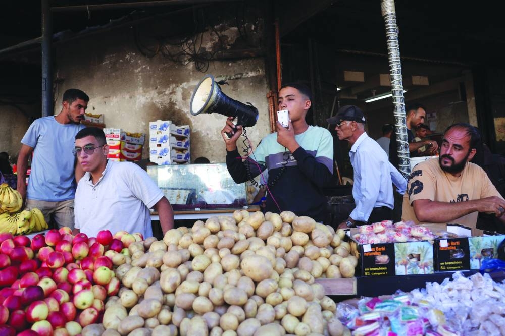 A vendor uses a megaphone to attract customers at a market in Deir el-Balah in the central Gaza Strip, Saturday.