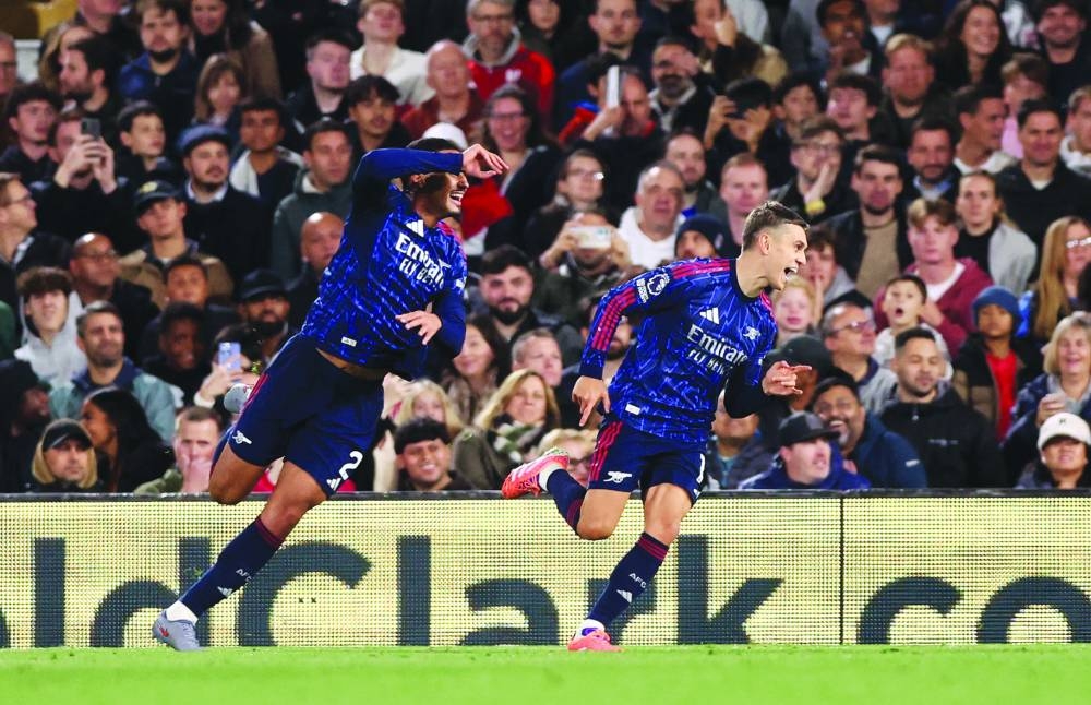 Arsenal’s Leandro Trossard (right) celebrates with William Saliba after scoring against Fulham at Craven Cottage in London. REUTERS