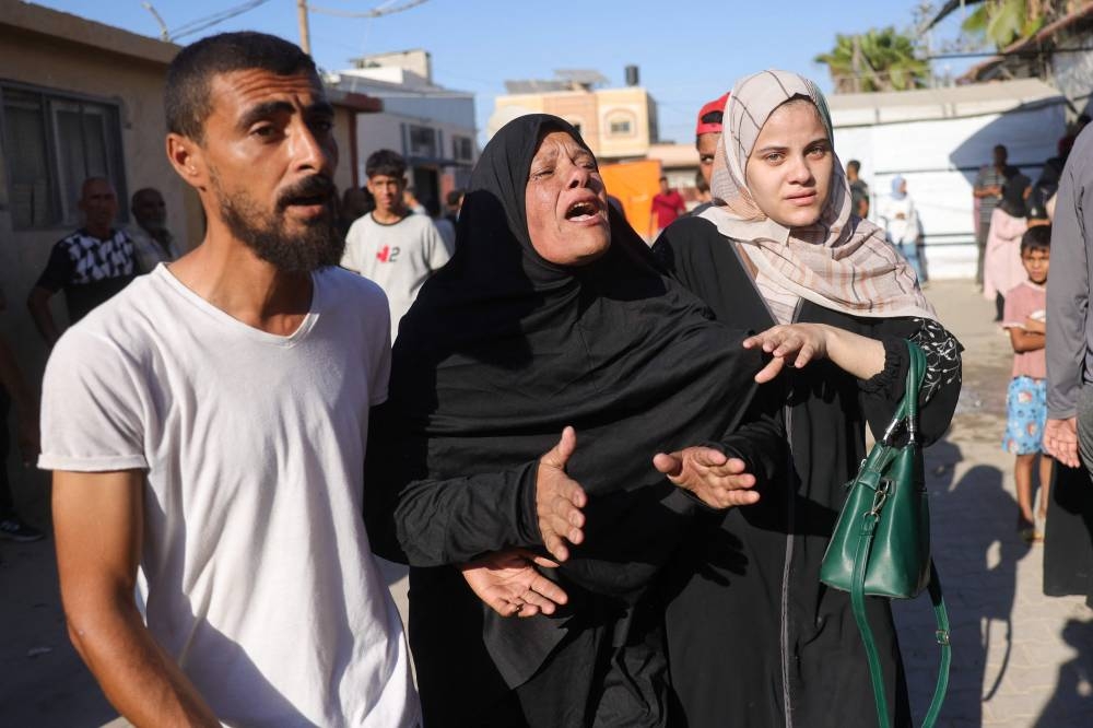 Friends and relatives mourn the death of a loved one who was killed during an Israeli strike earlier, outside Deir al-Balah's Shuhada al-Aqsa hospital in the central Gaza Strip on Sunday. AFP