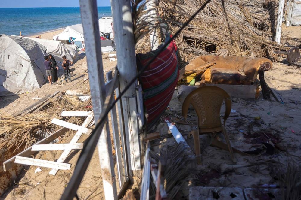 People stand next to their tents at the site of an Israeli strike that targeted the Galaxy Rest House west of Deir el-Balah in the central Gaza Strip that reportedly killed four Palestinians on Sunday. AFP