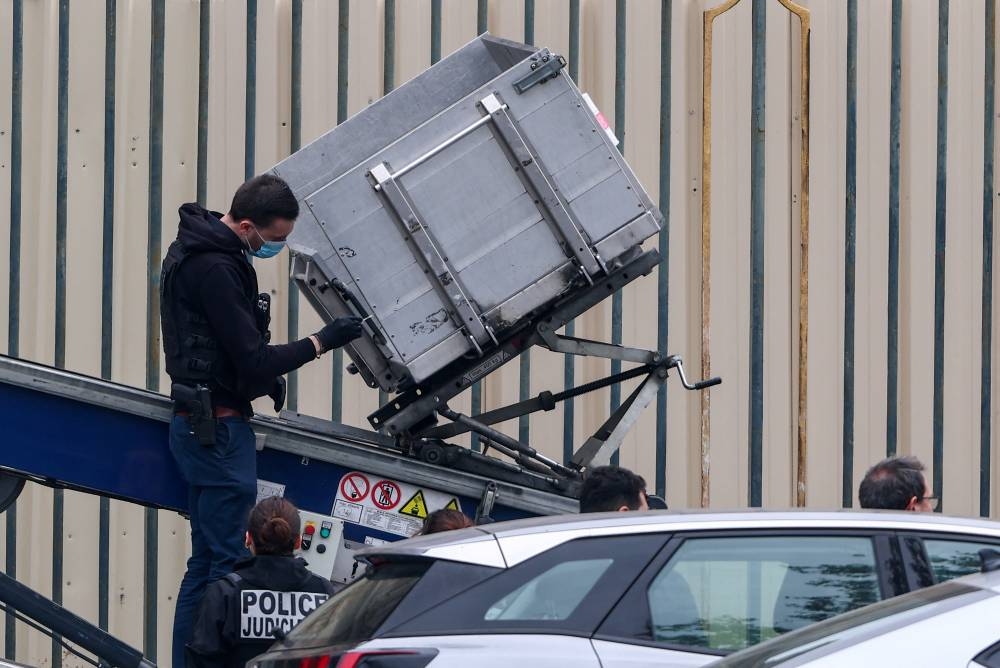 Police officers work at a crane believed to have been used in what the French Interior Ministry said was a robbery at the Louvre museum during which jewellery was stolen, in Paris, on Sunday. REUTERS