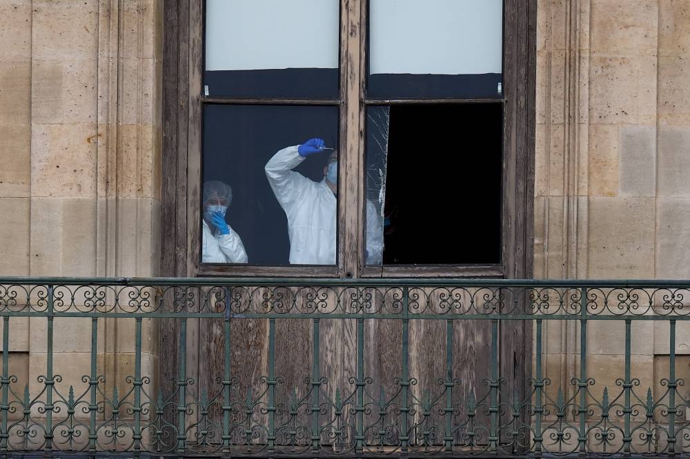 Members of a forensic team inspect a window believed to have been used in what the French Interior Ministry said was a robbery at the Louvre museum during which jewellery was stolen, in Paris, on Sunday. REUTERS