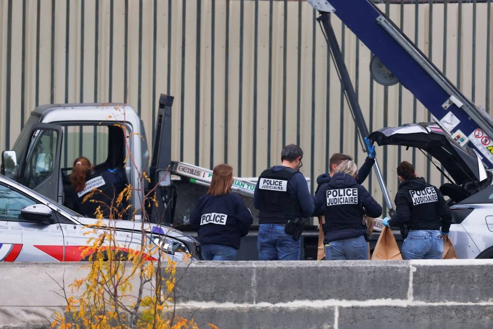 Police officers work near a crane believed to have been used in what the French Interior Ministry said was a robbery at the Louvre museum during which jewellery was stolen, in Paris, on Sunday. REUTERS