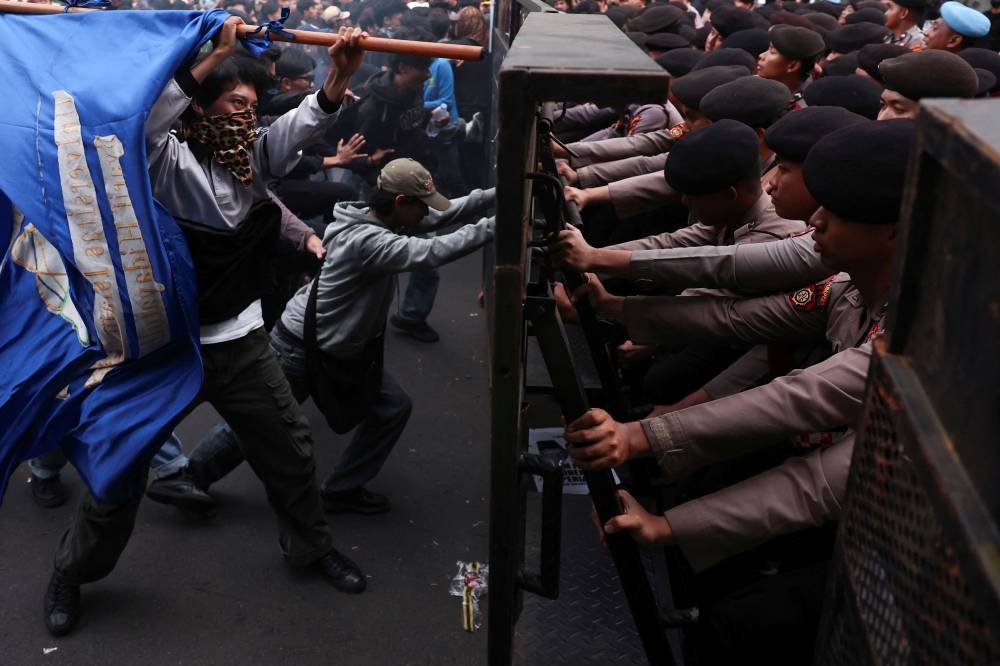 University students try to break a police barricade during a protest on the first anniversary of the Indonesian President Prabowo Subianto's administration, criticizing government policies, including the free meals programme, in Jakarta, on Monday. REUTERS