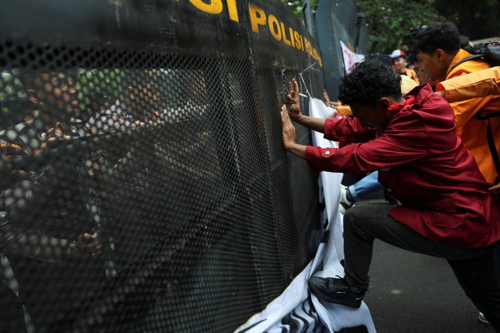 University students push police barricades during a protest on the first anniversary of President Prabowo's administration, criticising government policies, including the free meals programme, in Jakarta, on Monday. REUTERS