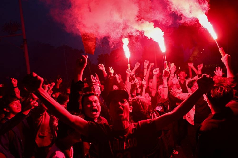 University students light flares during a protest on the first anniversary of Indonesian President Prabowo Subianto's administration, criticizing government policies, including the free meals programme, in Jakarta, on Monday. REUTERS