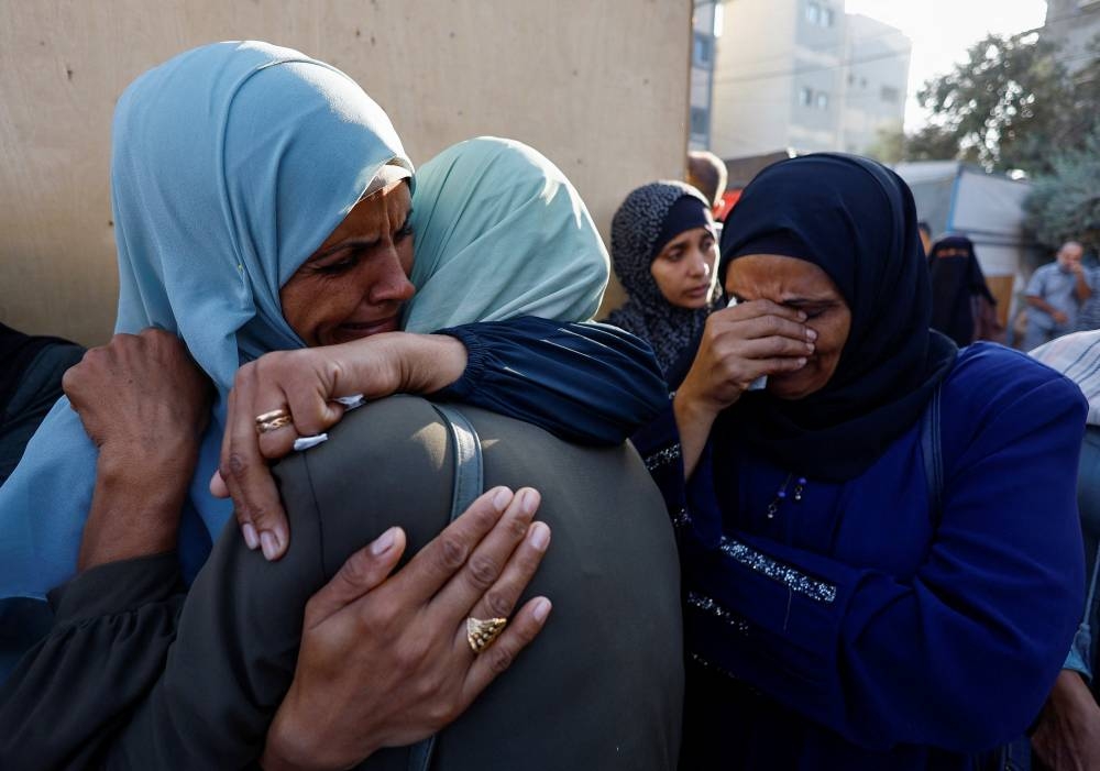 Mourners react as they attend the funeral of Palestinians killed in Sunday's Israeli strikes, according to medics, at al-Awda Hospital in the central Gaza Strip, on Monday. REUTERS