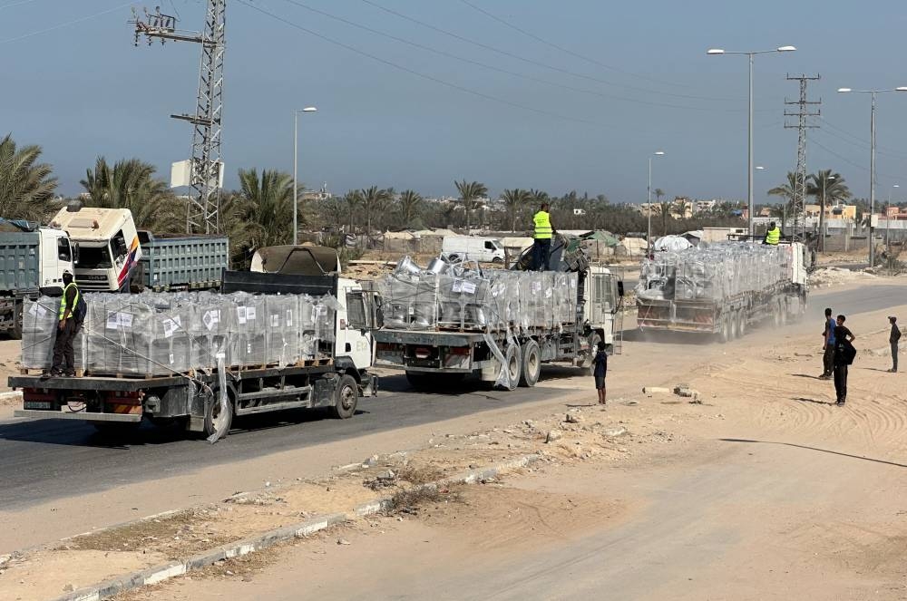 Trucks carry aid for Palestinians, amid a ceasefire between Israel and Hamas in Gaza, in Deir Al-Balah, in the central Gaza Strip, on Tuesday. REUTERS