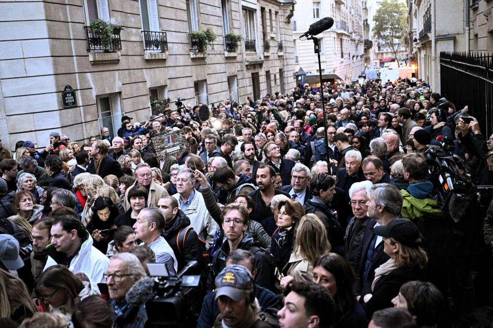 Supporters of France's former president Nicolas Sarkozy gather outside his residence ahead of his departure to La Sante prison for incarceration on a five-year prison sentence, in Paris on Tuesday. AFP