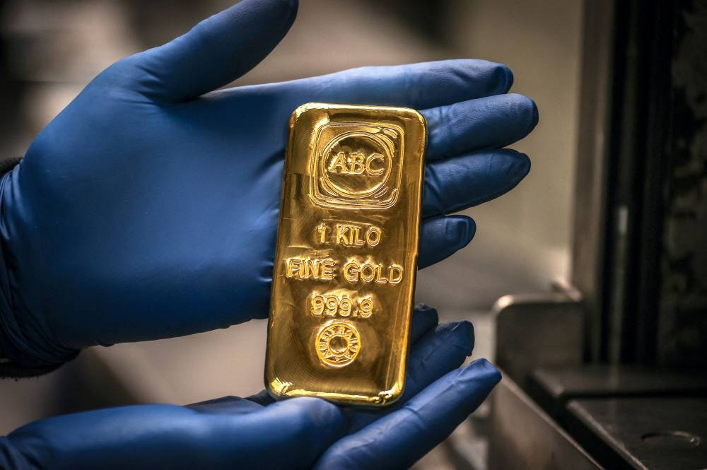 A worker displays a one-kilogram gold bullion bar at the ABC Refinery in Sydney.  (AFP)