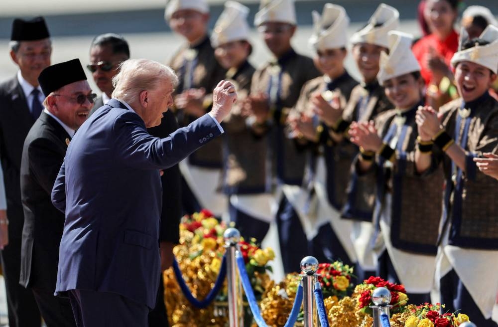 US President Donald Trump (C) joins performers for a dance during the welcome ceremony next to Malaysia's Prime Minister Anwar Ibrahim (L) as he arrives on Air Force One at Kuala Lumpur International Airport in Kuala Lumpur on October 26, 2025. US President Donald Trump arrived in Malaysia on October 26 on the first leg of an Asian tour that will include high-stakes trade talks with Chinese counterpart Xi Jinping. (AFP)