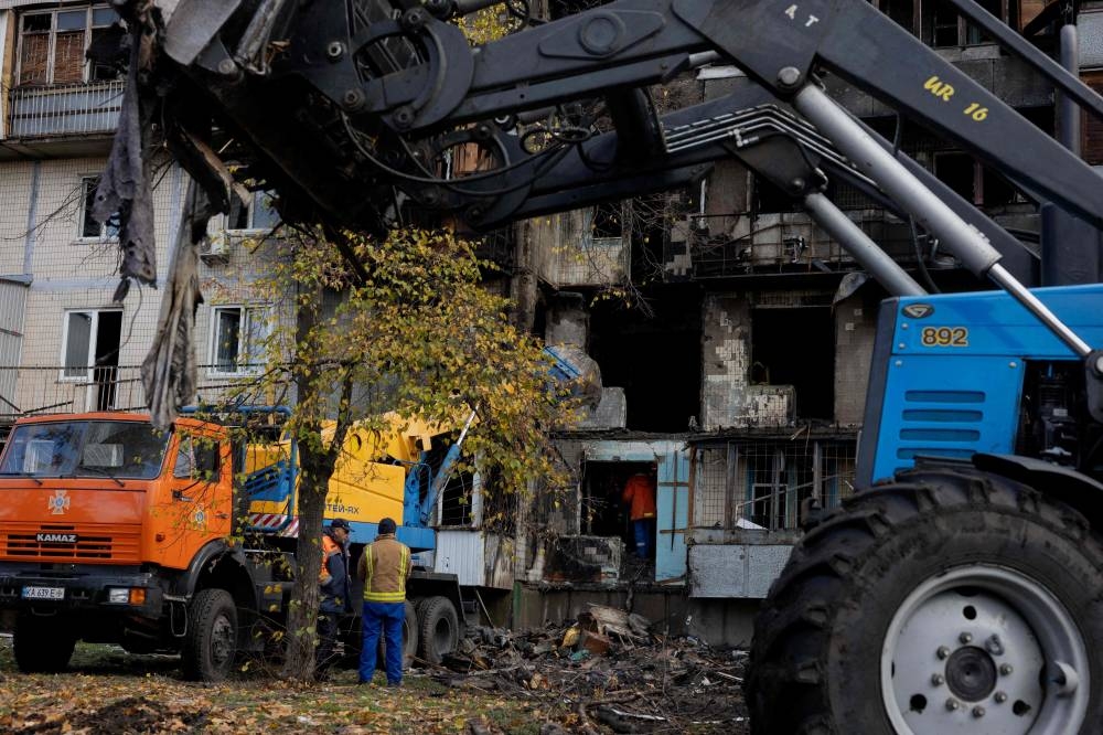 Rescuers work as they search a damaged residential building following a drone attack in Kyiv, on October 26, 2025, amid the Russian invasion of Ukraine. (AFP)