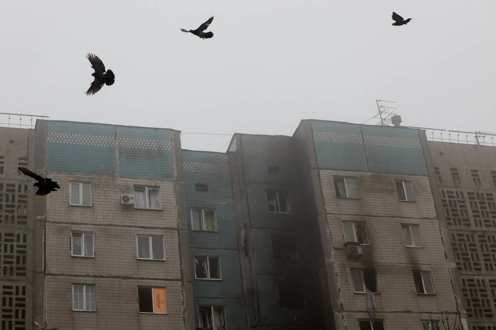 Birds fly near the burnt facade of a multi-storey residential building damaged during what Russian-installed authorities described as a Ukrainian overnight drone attack, amid the ongoing Russia-Ukraine conflict in Donetsk, a Russian-controlled city of Ukraine, on Monday. REUTERS