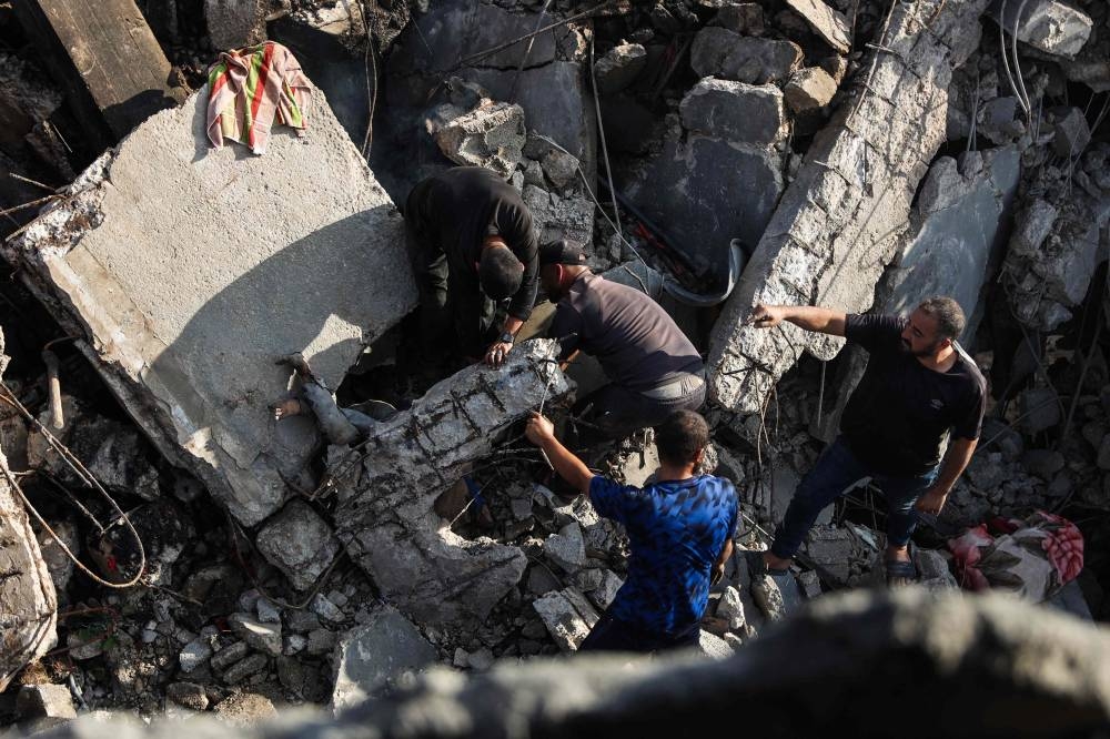 Palestinians recover a body from the rubble of a house destroyed in an overnight Israeli strike in Gaza City, on Wednesday. AFP