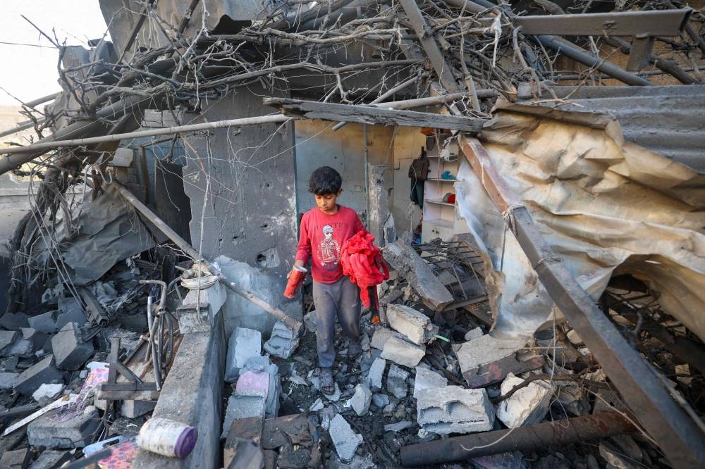 A boy walks amid the rubble of a house destroyed in an Israeli strike in Nuseirat, in the central Gaza Strip, on Wednesday. AFP