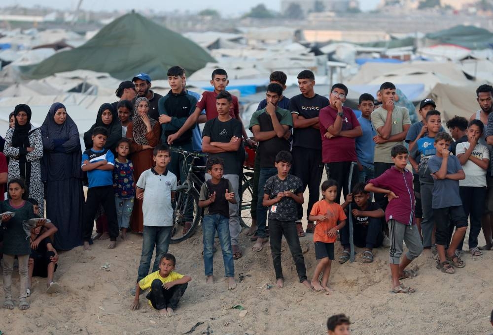 People gather during the search for the bodies of deceased hostages, in Khan Younis, southern Gaza Strip, on Tuesday. REUTERS
