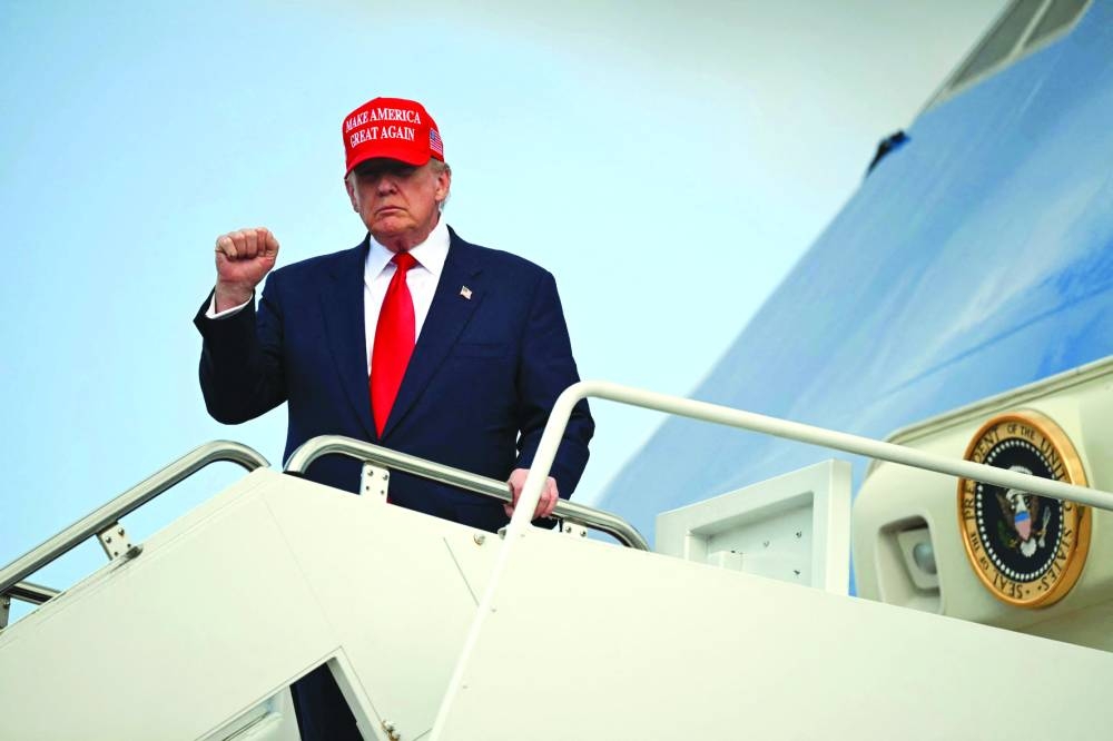 Trump gestures as he steps off Air Force One upon arrival at Joint Base Andrews in Maryland yesterday.
