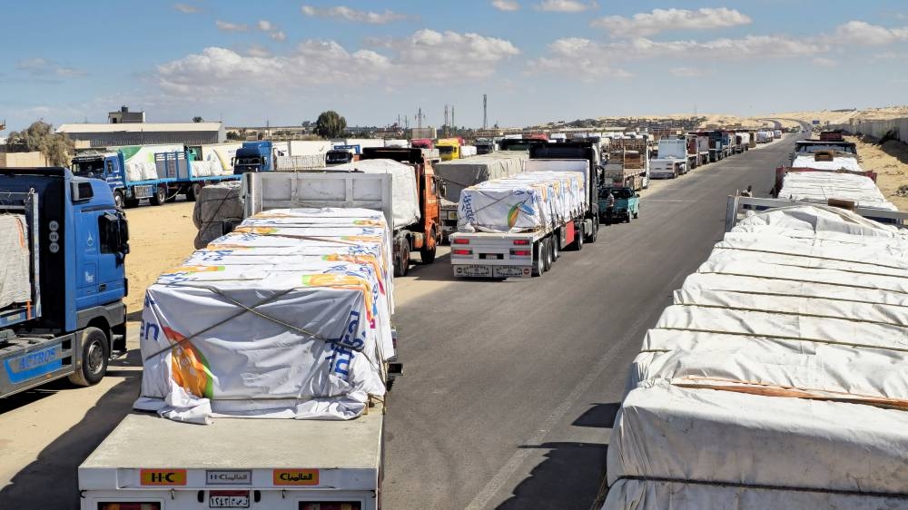 Trucks carrying humanitarian aid prepared by the Egyptian Red Crescent, which are to enter the Rafah crossing into the Gaza Strip on October 15, line up, after a ceasefire between Israel and Hamas in Gaza went into effect, in Al-Arish, the capital of the North Sinai Governorate, Egypt.  REUTERS