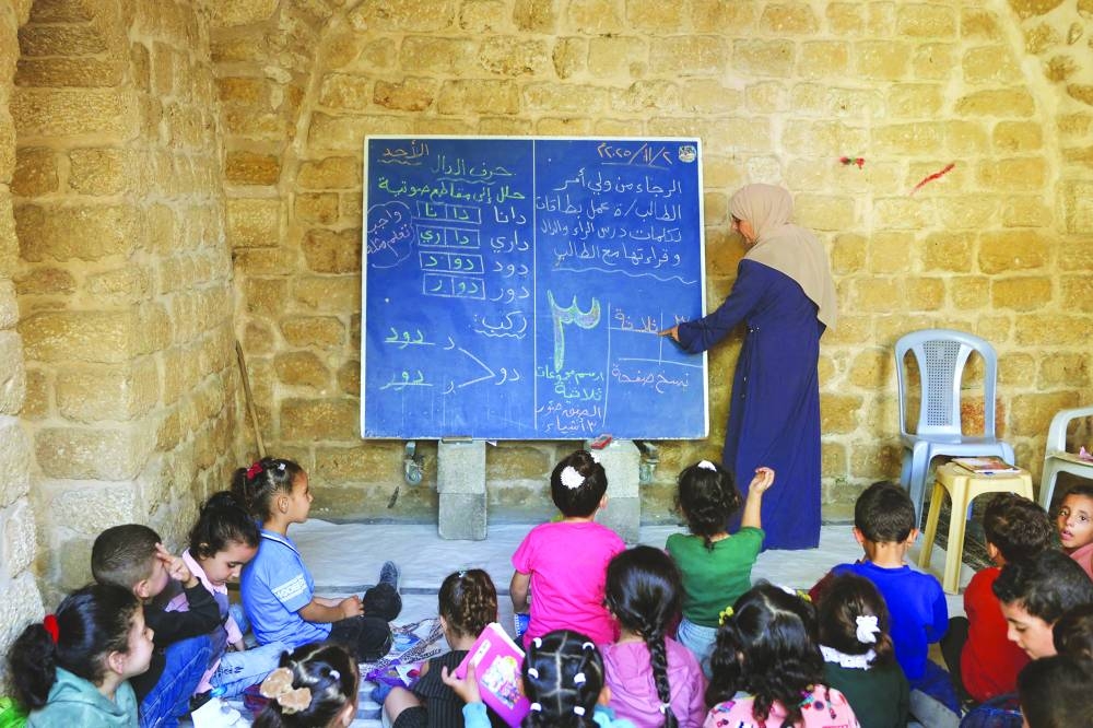 Palestinian children attend a class in the historic "Al-Kamaliya al-Othmanya" school in Gaza City's Old Town, as part of a volunteer initiative organised by displaced teachers, in Gaza City, yesterday.