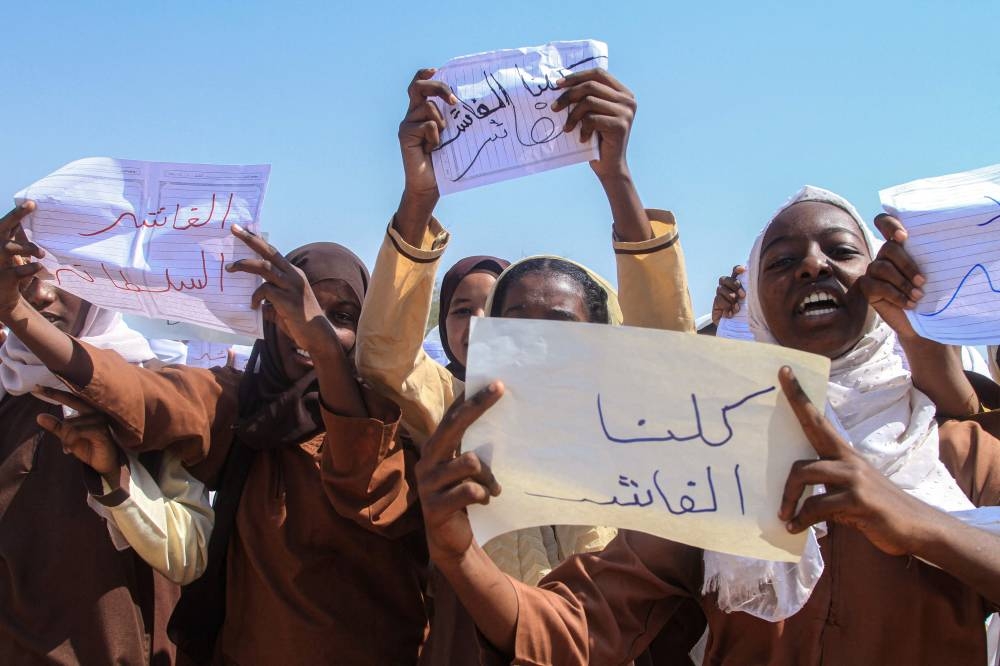 A Sudanese Student from a school in the East Nile region of the capital, holds a sign that reads in Arabic, "We are all El-Fasher" during a protest against violations committed by the Rapid Support Forces (RSF) against the people of El- Fasher, in Khartoum on Monday. AFP