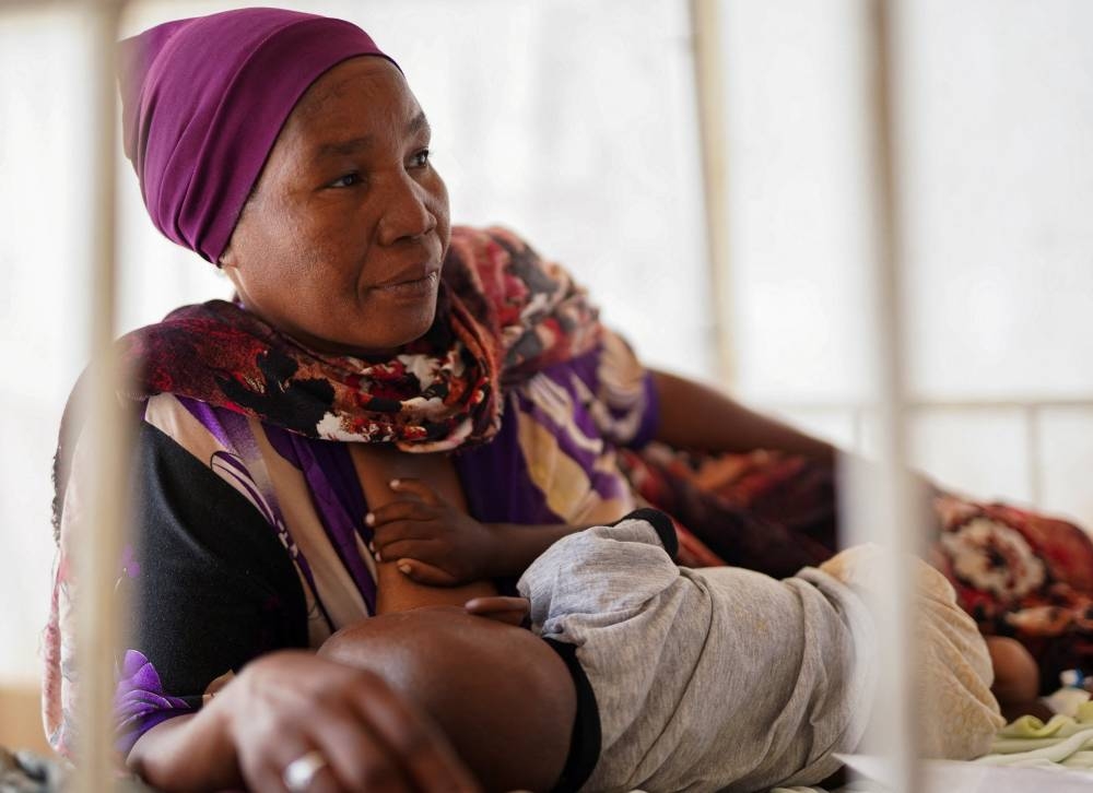A displaced Sudanese woman who fled violence in El-Fasher breastfeeds her child at a makeshift clinic run by Medecins Sans Frontieres (MSF), in Tawila, North Darfur, on Monday. REUTERS