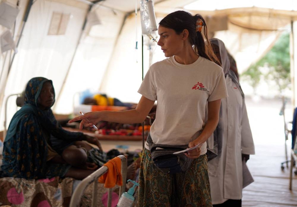 A member of Medecins Sans Frontieres (MSF) counts injured displaced Sudanese people who fled violence in El-Fasher and are receiving treatment at a makeshift clinic run by MSF, in Tawila, North Darfur, on Monday. REUTERS