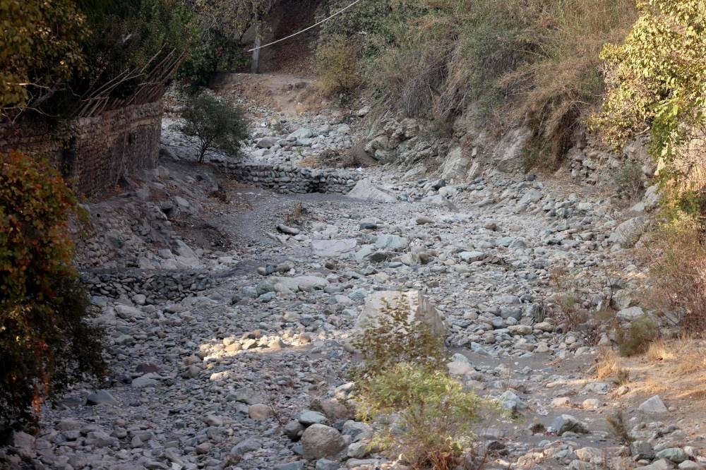 Rocks and pebbles cover the riverbed of the dried-up Kan River, west of Tehran, Sunday, as Iran faces severe water shortages.
