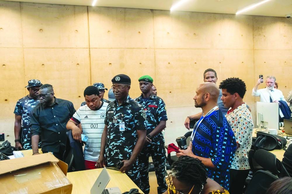 Nigeria's Police Commissioner Monday Agbonika (fourth left) stands beside the leader of the protesters (third left) while addressing guests after protesters disrupt the opening of the Museum of West African Art in Benin City, Edo State, Sunday.